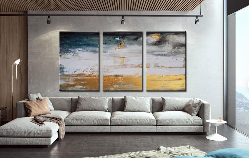 Drieluik schilderij ophangen boven een bank in een moderne woonkamer